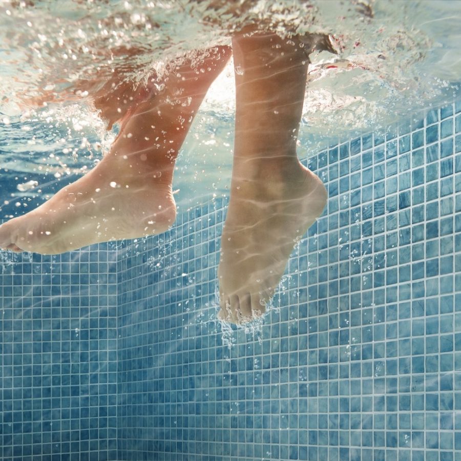 detail of kid feet on a  swimming pool